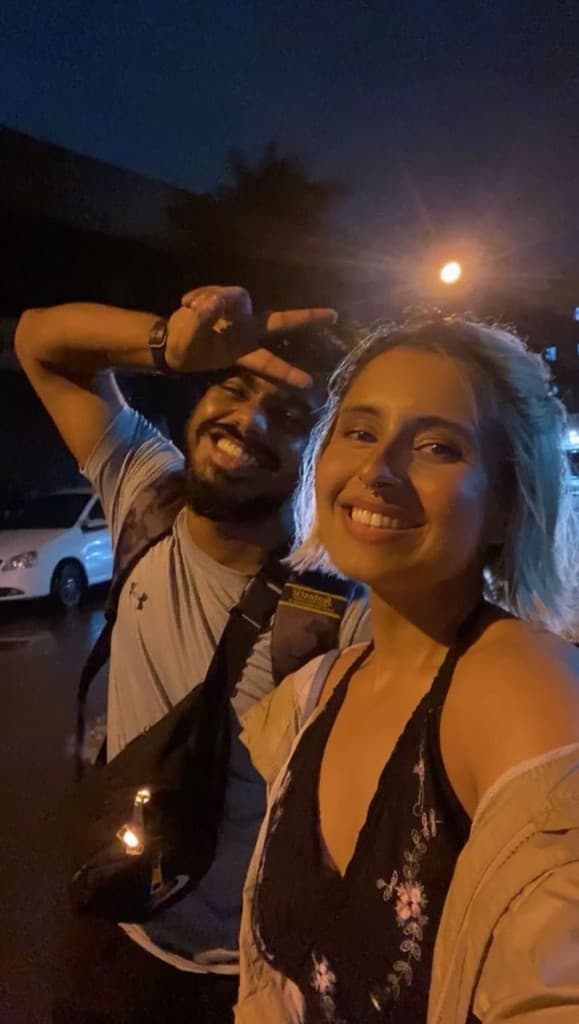 Nairaah Sharma and coach smiling together outdoors at night