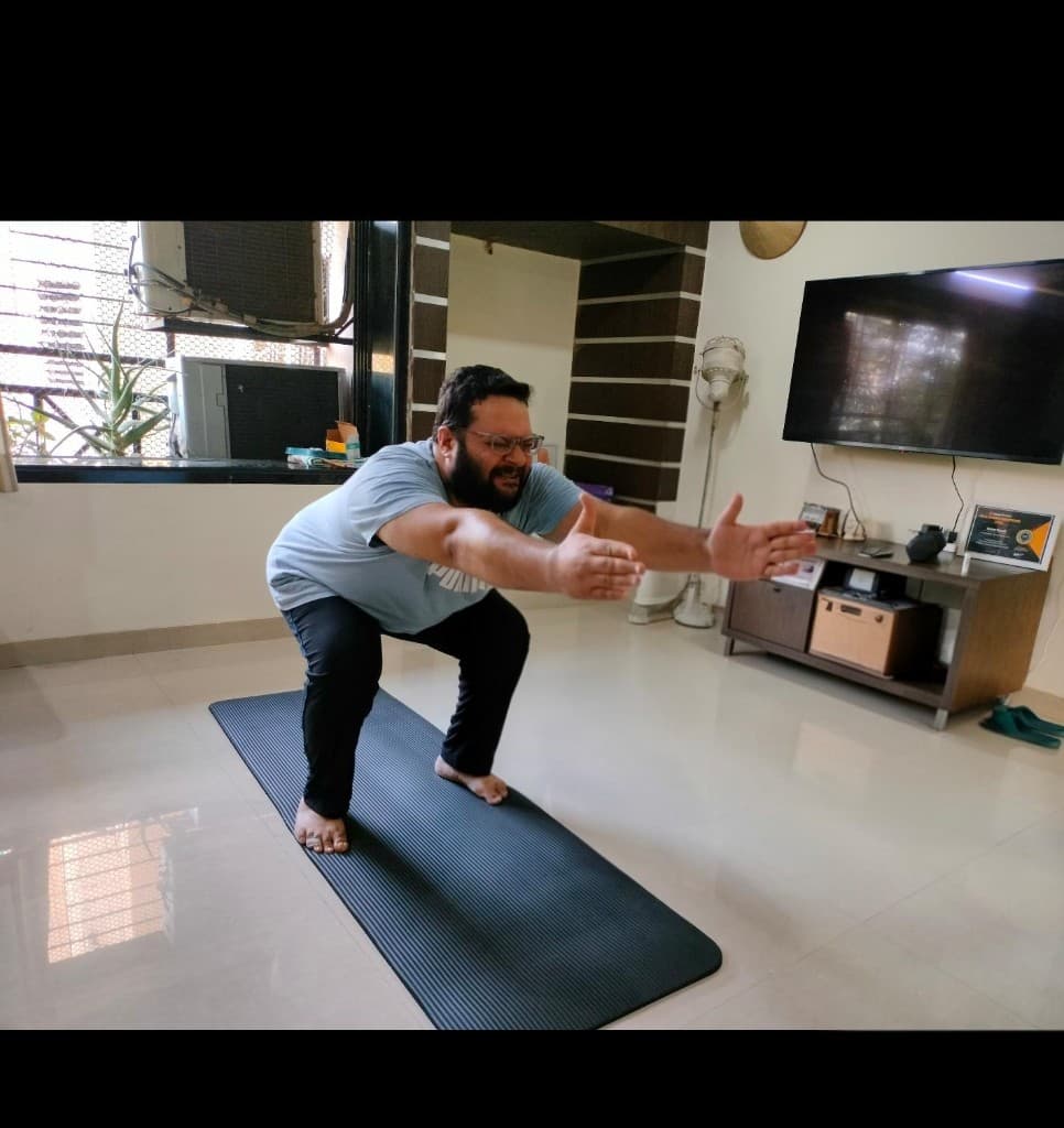 Client performing a limited-depth squat at home before coaching